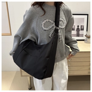 Détail d'un grand sac hobo noir en nylon avec bandoulière réglable pour un usage quotidien
