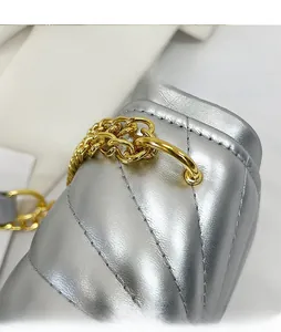 Detail of silver quilted leather bag showing gold chain strap and luxury metal hardware