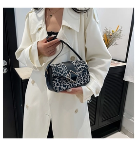 Detail of leopard print handbag with black leather trim and large square metal buckle