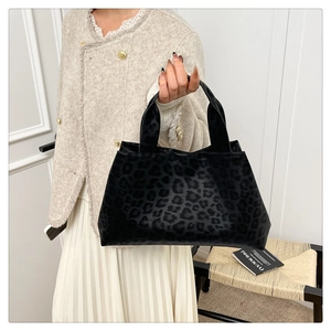 Close-up of trapezoidal leopard print tote bag with premium faux fur texture and dual handles
