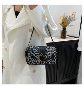 Detail of leopard print shoulder bag with black leather strap and square metal buckles