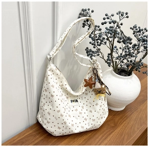 Detail of corduroy tote bag with bow prints and cute bear star bag charms