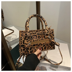 Dettaglio della borsa leopardata francese con manici cilindrici e cerniera con nappina