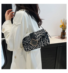 Detail of leopard print shoulder bag featuring black leather flap and gold square buckle