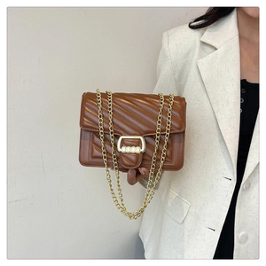 Close-up of brown quilted faux leather bag with gold chain strap and metal clasp
