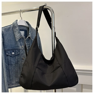 Détail de la bandoulière réglable et de la boucle métallique du sac hobo noir
