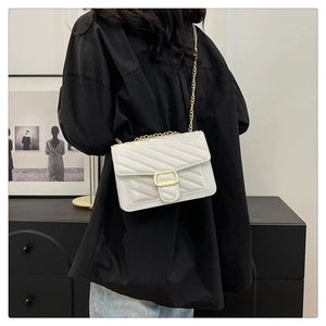 Detail shot of white quilted crossbody bag with gold hardware and V-stitch pattern