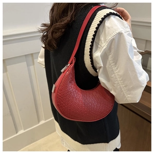 Detail of red woven hobo bag showing the intricate texture and silver metal buckles