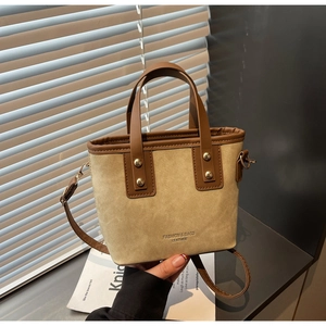 Détail du sac seau bicolore avec poignées en cuir et gravure dorée fashion