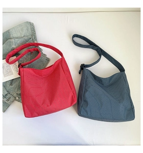 Flat lay of vintage plaid canvas hobo bags in red and navy with adjustable straps