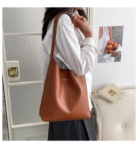 Detailed close-up of brown faux leather tote bag featuring gold FASHION typography
