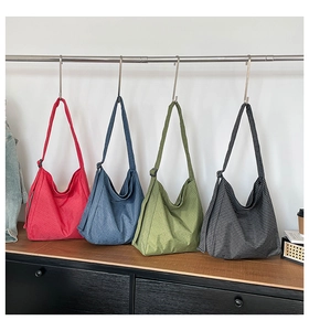 Close-up of four colorful plaid tote bags with adjustable straps hanging on a rack