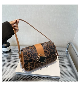 Detail of leopard print handbag featuring a unique geometric gold and black metal clasp