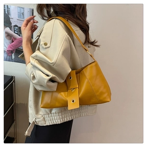 Detail of yellow PU leather shoulder bag with vintage gold stud hardware on strap