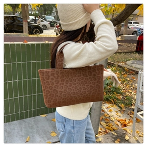 Close-up of leopard print tote bag texture in a cozy autumn street style setting