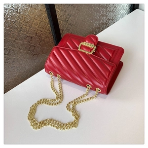 Detailed view of red quilted leather texture and gold metal buckle on chain shoulder bag