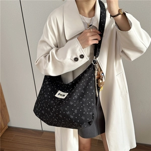 Large black corduroy tote bag with heart patterns and adjustable logo strap