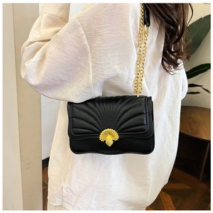 Detailed back view of a black quilted crossbody bag with a golden shell-shaped metal lock