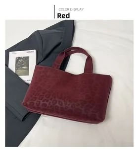 Detail view of a vintage leopard print tote bag in deep red with a suede-like texture