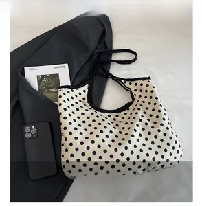 Minimalist polka dot canvas tote bag with black trim styled with a magazine and smartphone