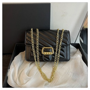 Detailed close-up of a black V-quilted faux leather bag with elegant gold chain strap
