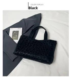 Detailed macro view of black leopard print tote bag on white background with magazine