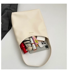 Detailed interior view showing high capacity of minimalist beige tote bag and gold logo