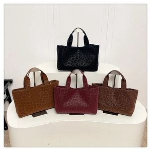 Detail view of stylish leopard print tote bags in four colors with suede texture