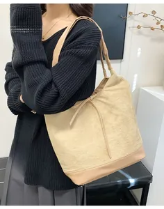 Detail of large beige canvas tote bag with khaki leather stitching on the handles