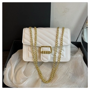 Close-up of white quilted leather crossbody bag with elegant gold buckle and chain strap