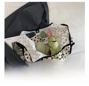 Spacious interior of canvas tote bag with polka dot pattern showing phone and umbrella