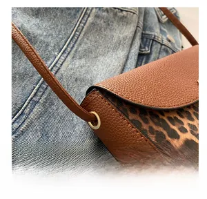 Detail of saddle bag featuring brown lychee leather and leopard print patchwork