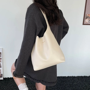 Minimalist beige hobo tote bag in matte leather featuring gold fashion lettering