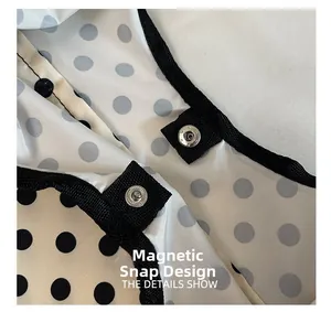 Detail view of silver magnetic buckle closure and polka dot pattern on canvas tote bag