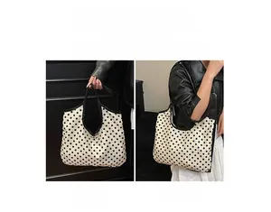 Detailed view of polka dot canvas tote bag showing both hand-carry and shoulder-wear options
