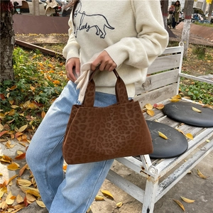 Retro leopard print tote bag for women shown in an autumn park setting with fallen leaves