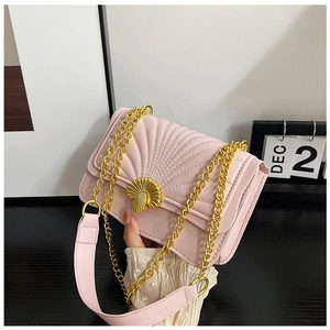 Detail of light pink quilted bag featuring fan patterns and a gold shell clasp