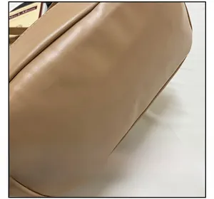 Close-up of contrast white stitching on a premium beige faux leather shoulder bag detail