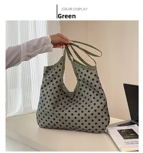 Detail view of large green polka dot canvas tote bag with comfortable carry handles