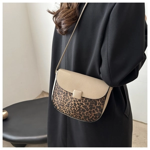 Close-up of leopard print saddle bag with beige pebbled leather and elegant square buckle