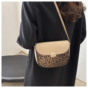 Detail of saddle bag showing beige pebbled leather and leopard print flap on coat
