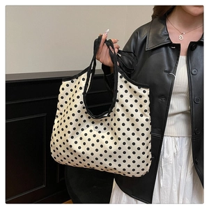 Close-up of black polka dot canvas tote bag featuring premium fabric and contrast handles