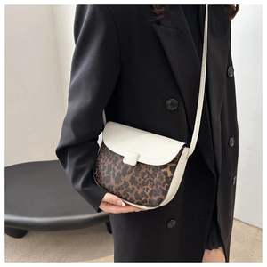 Detail of saddle bag featuring leopard print panel and white textured leather finish