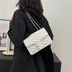 Close-up of white V-quilted faux leather crossbody bag with elegant gold chain strap