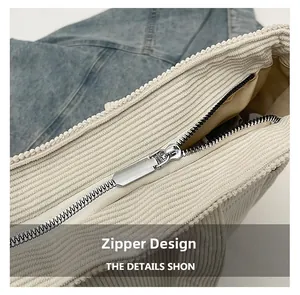 Close-up of silver metal zipper and smooth inner lining on corduroy tote bag