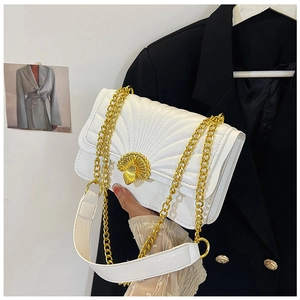 Detail of white quilted handbag with golden shell clasp and metal chain strap