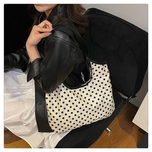 Macro shot of durable canvas polka dot tote bag with black woven straps and large capacity
