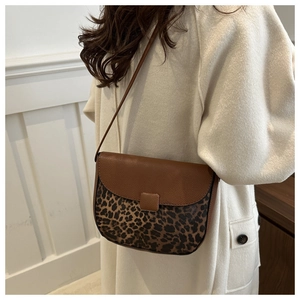 Detail of contrast stitch saddle bag with leopard print and brown pebble leather texture