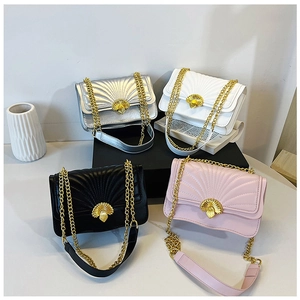 Detail view of four quilted crossbody bags with scallop locks in silver, white, black and pink
