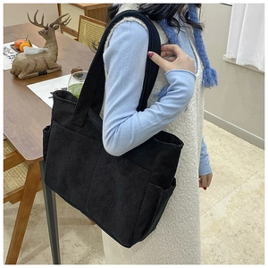 Detail view showing black corduroy texture and side pocket of the large tote bag